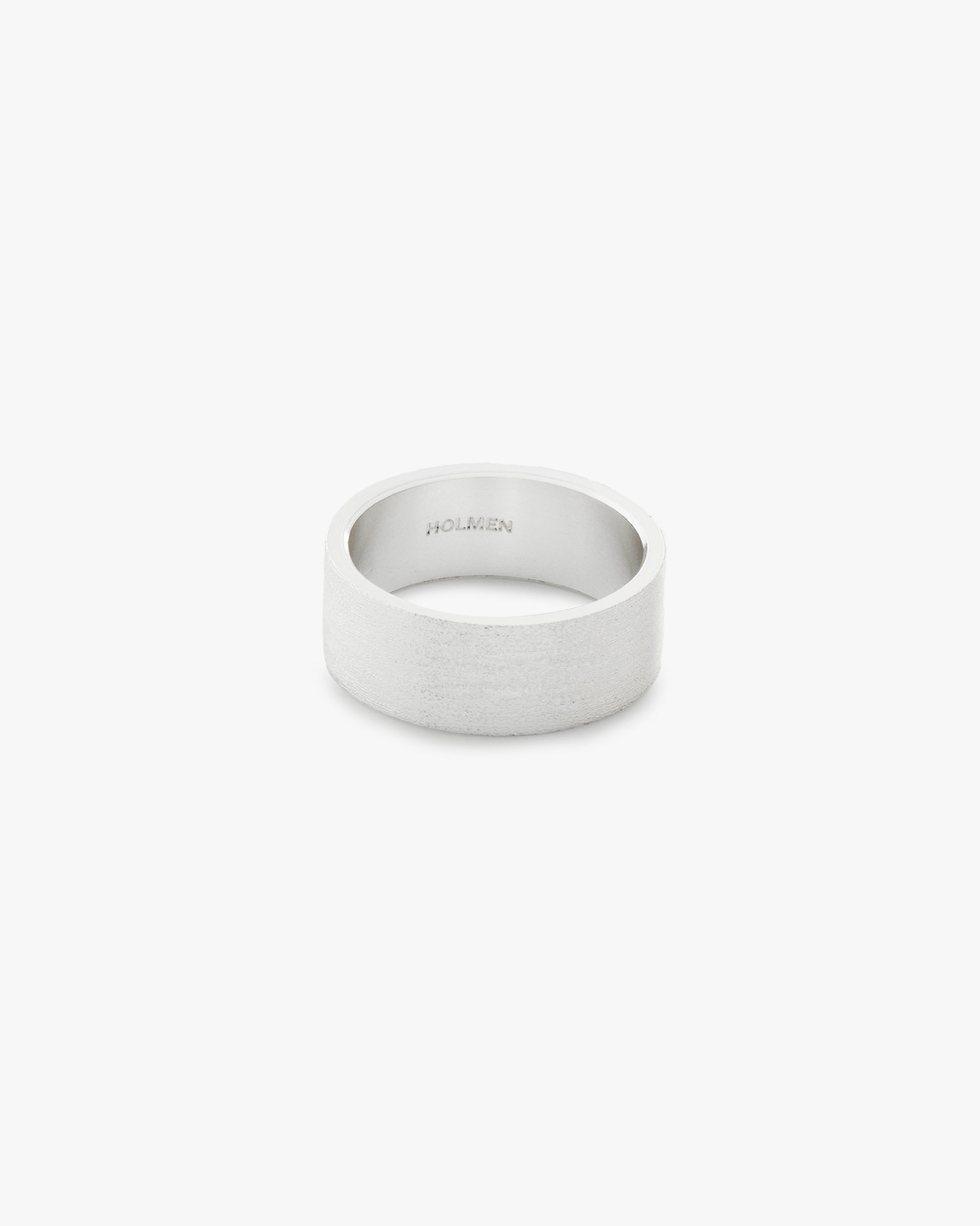 Silver ring with "HOLMEN" branding on a light grey background
