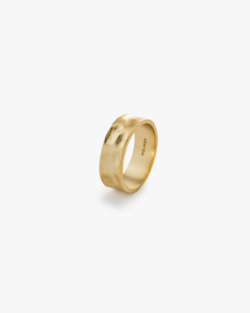 Gold ring on a light grey background