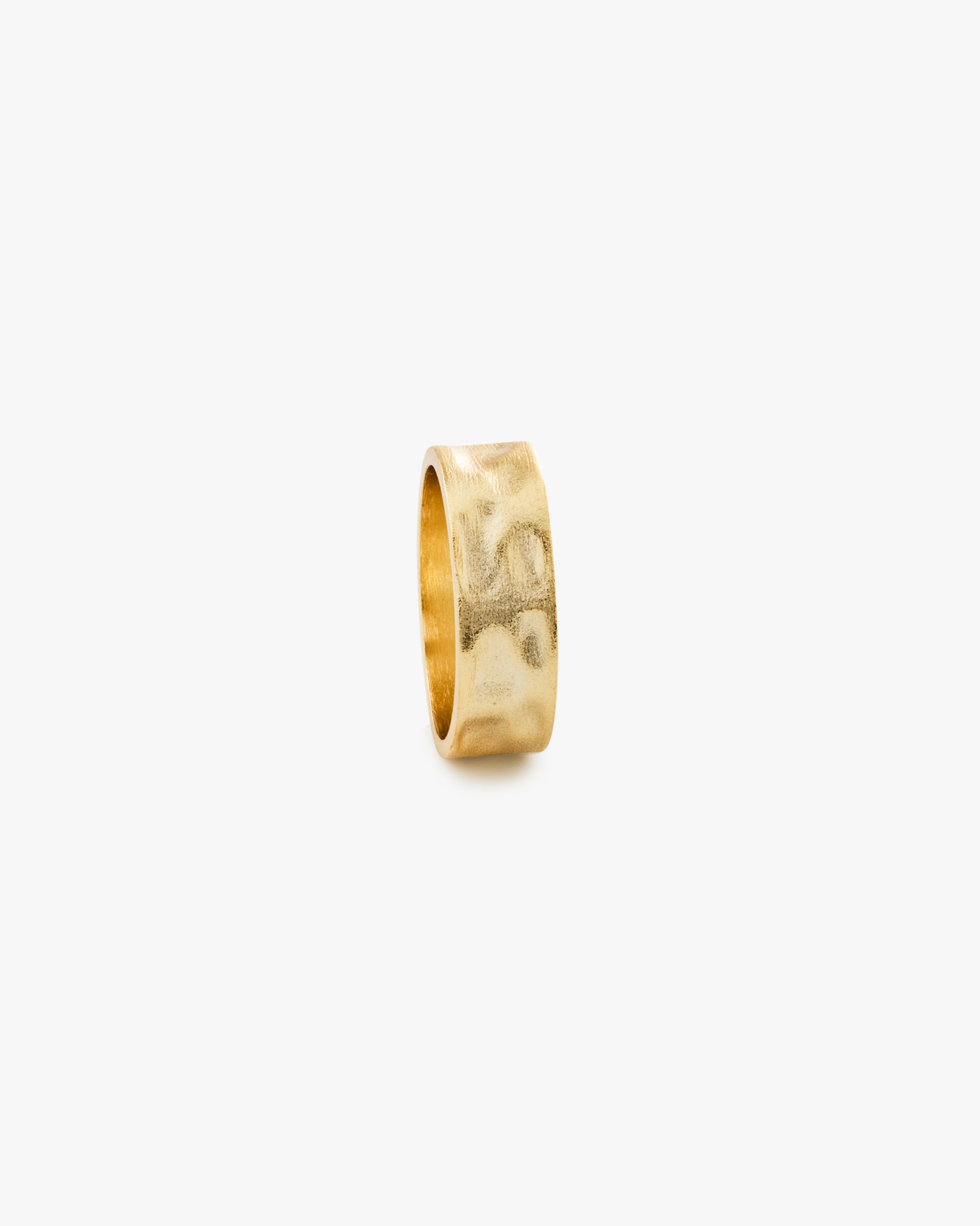 Gold ring with a textured finish on a light grey background