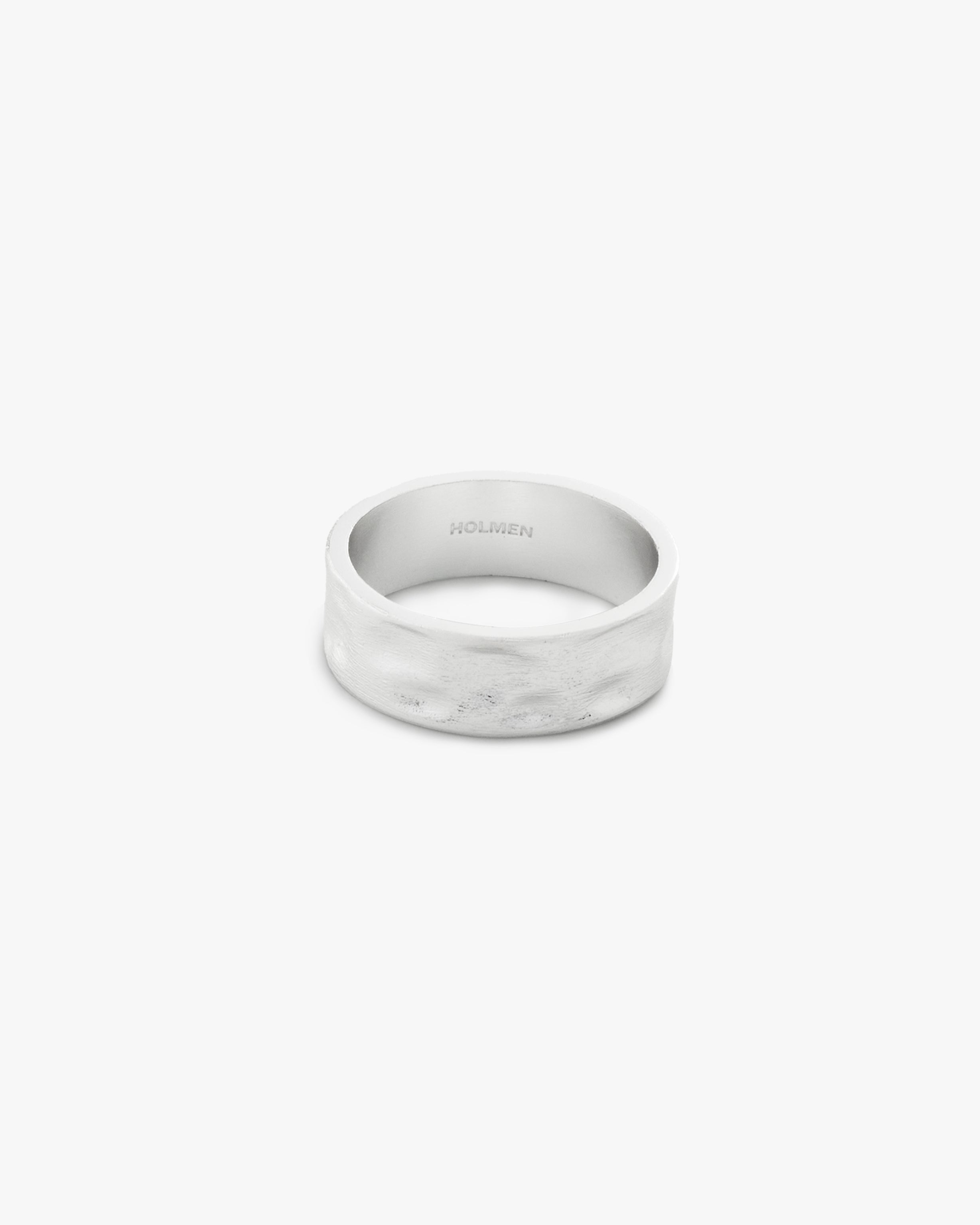 Silver ring hammered with on a light grey background