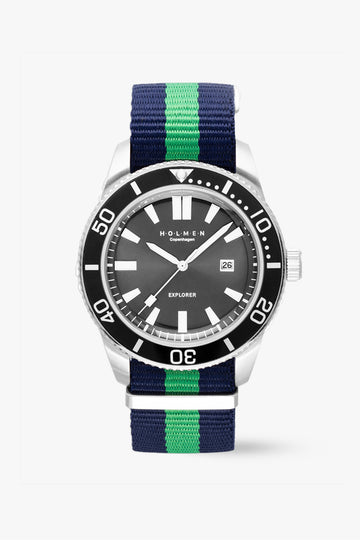 Watch with a black dial and blue and green striped strap on a white background