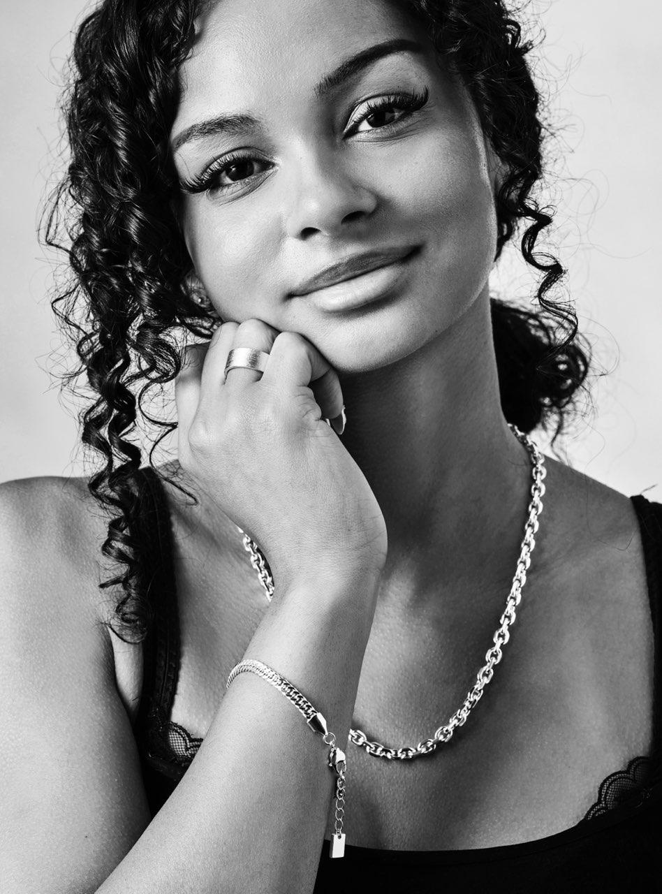 Black and white portrait of a woman wearing jewelry with a neutral background