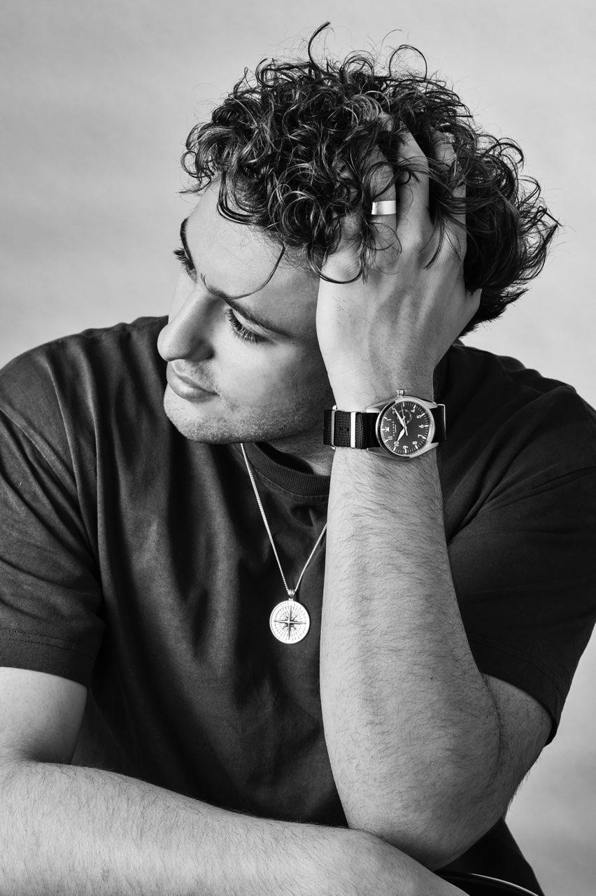 Man wearing a watch with a neutral background