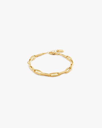 Gold chain bracelet on a light grey background