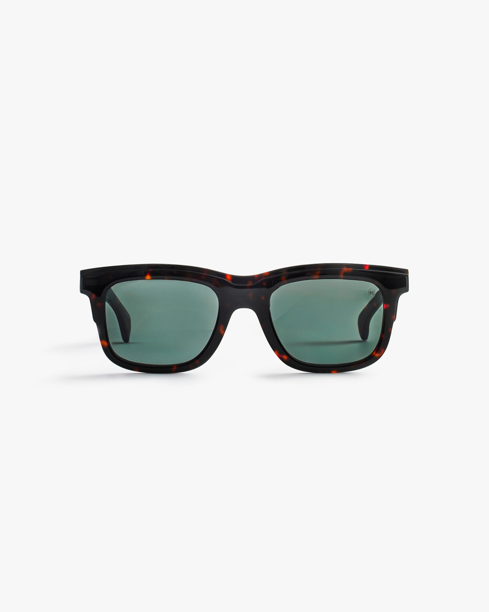 Sunglasses black structured frame and green lenses on a light grey background