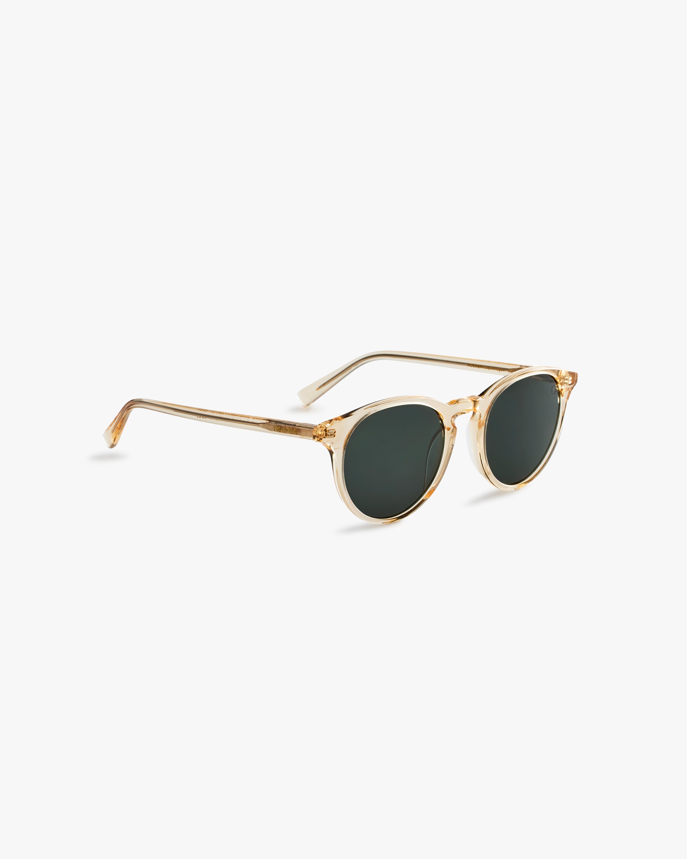 Gold-framed sunglasses with dark lenses on a light grey background