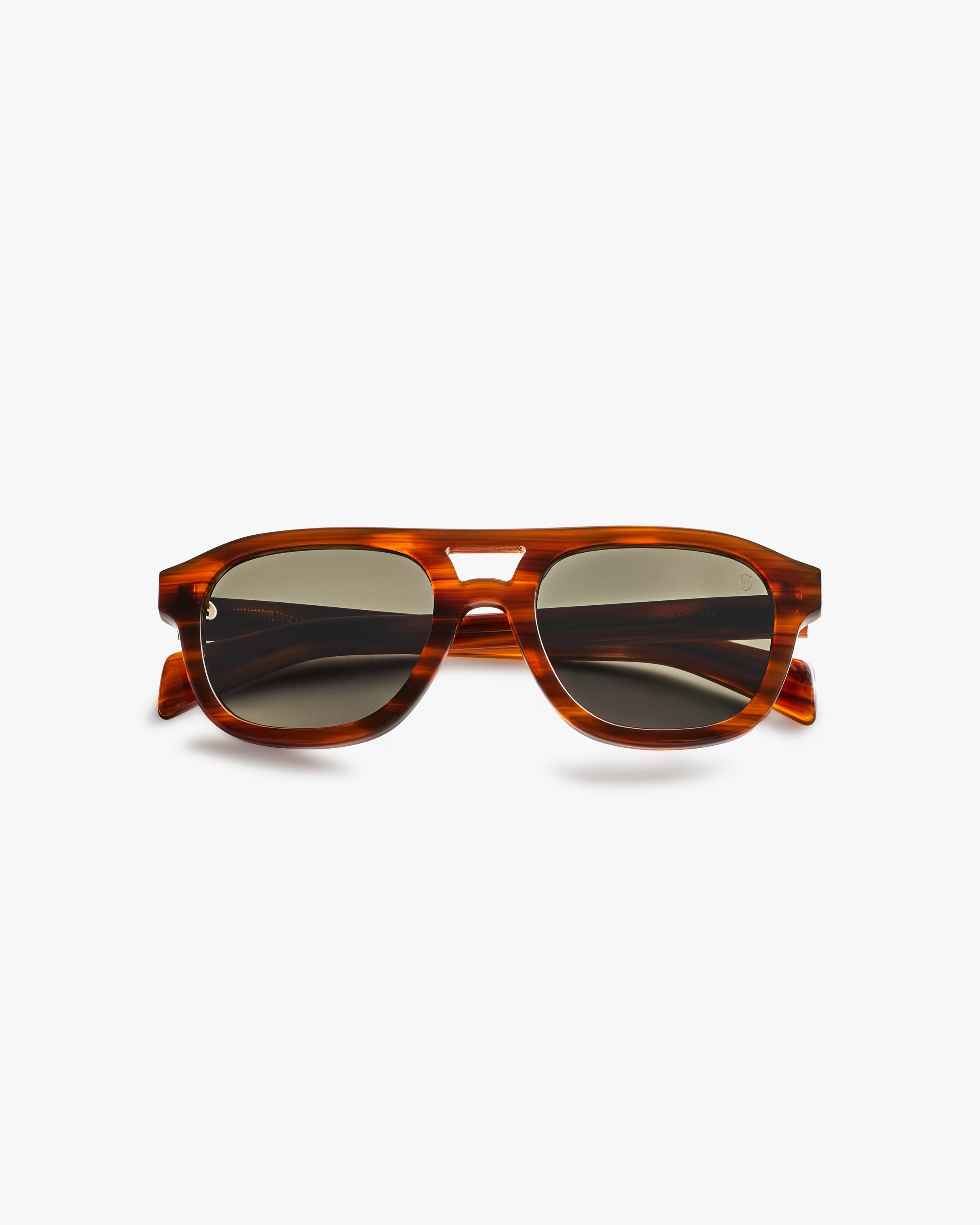 Brown sunglasses with a tortoiseshell frame on a light grey background