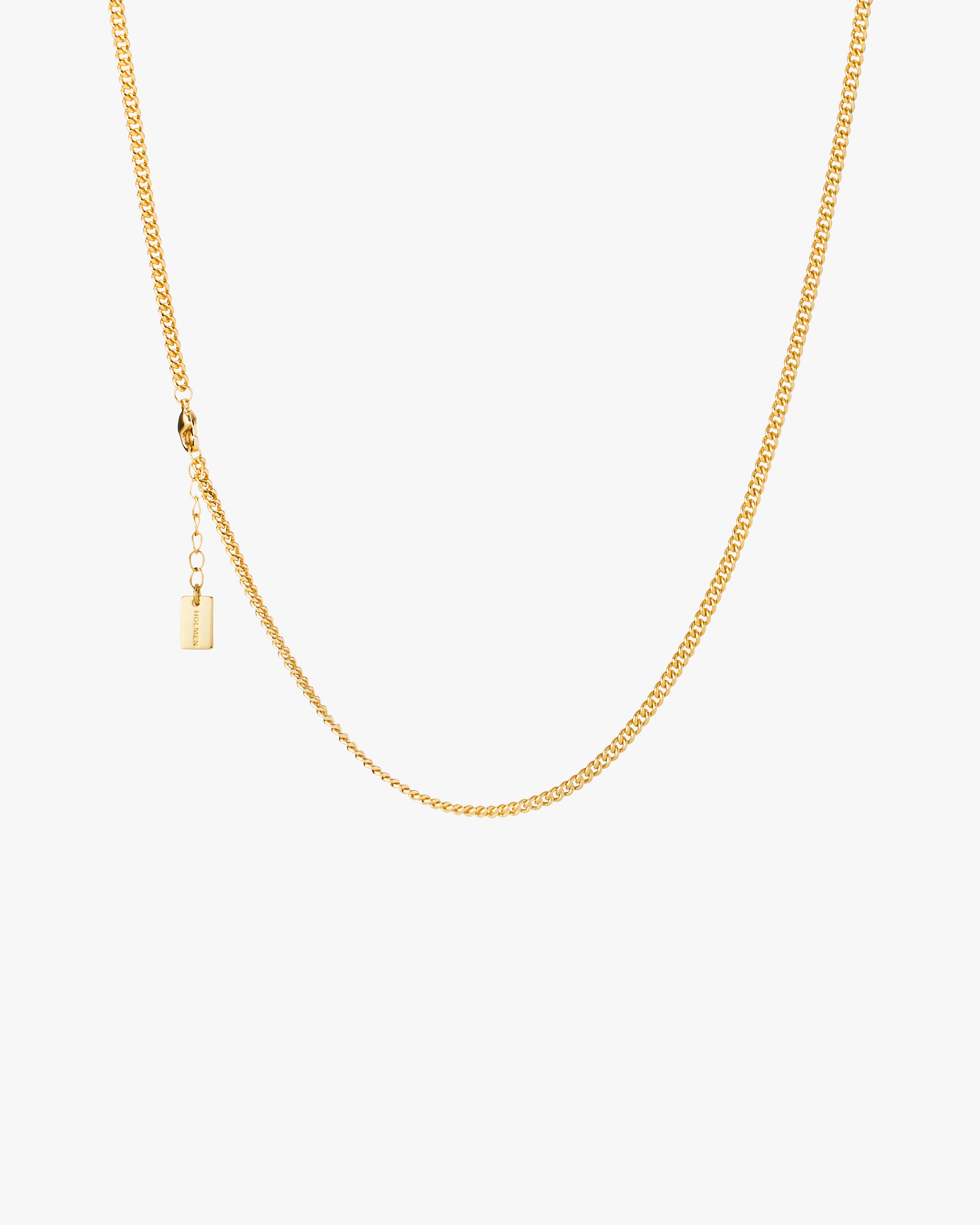 Gold chain necklace on a light grey background