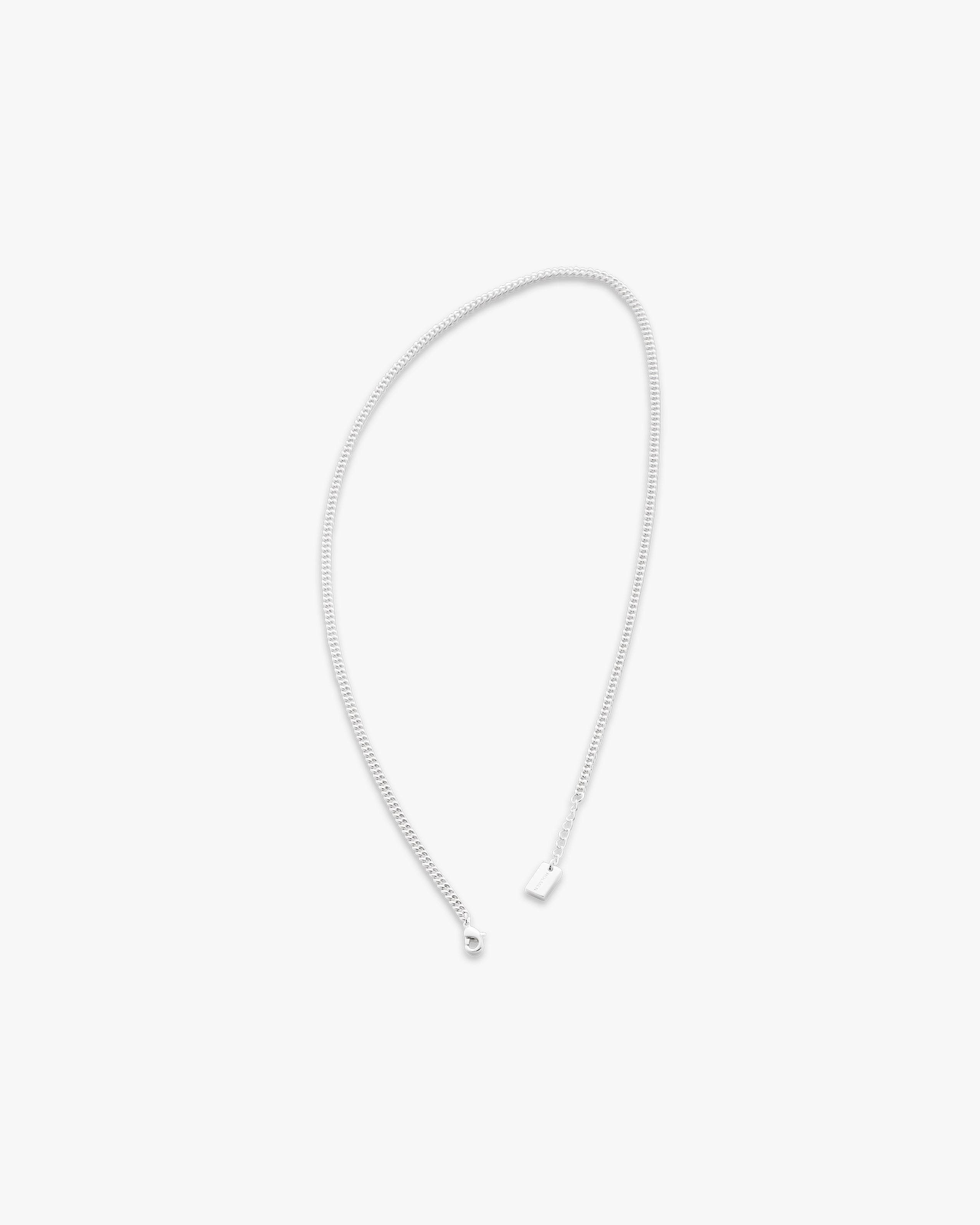 Silver chain necklace on a light gray background